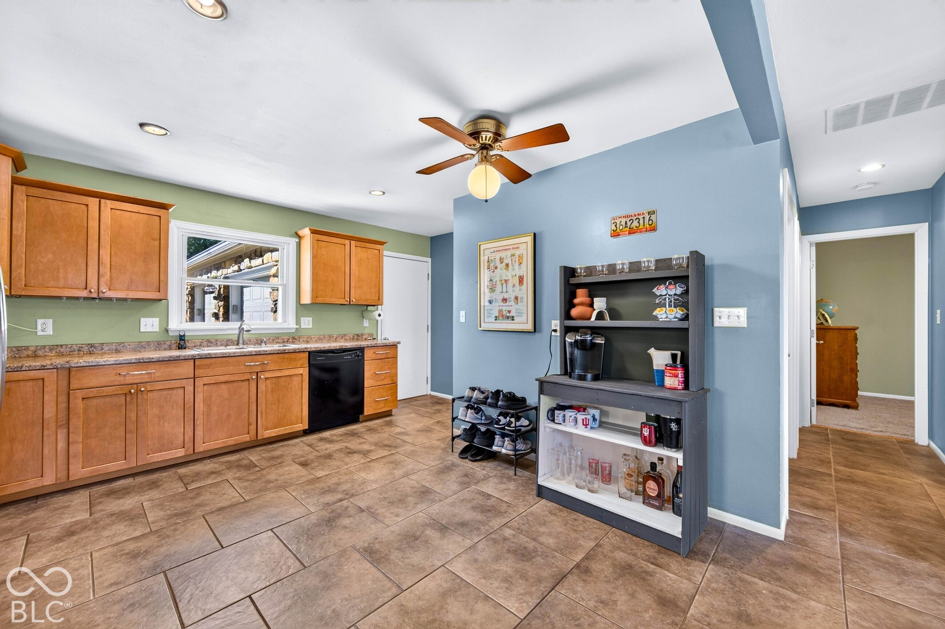 Kitchen featuring wood cabinetry, a built-in dishwasher, and a window above the sink