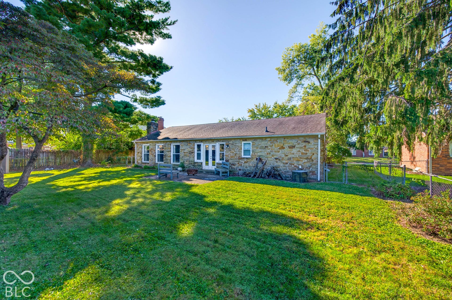 Stone exterior with a shingle roof, complemented by multiple windows and a double French door entry