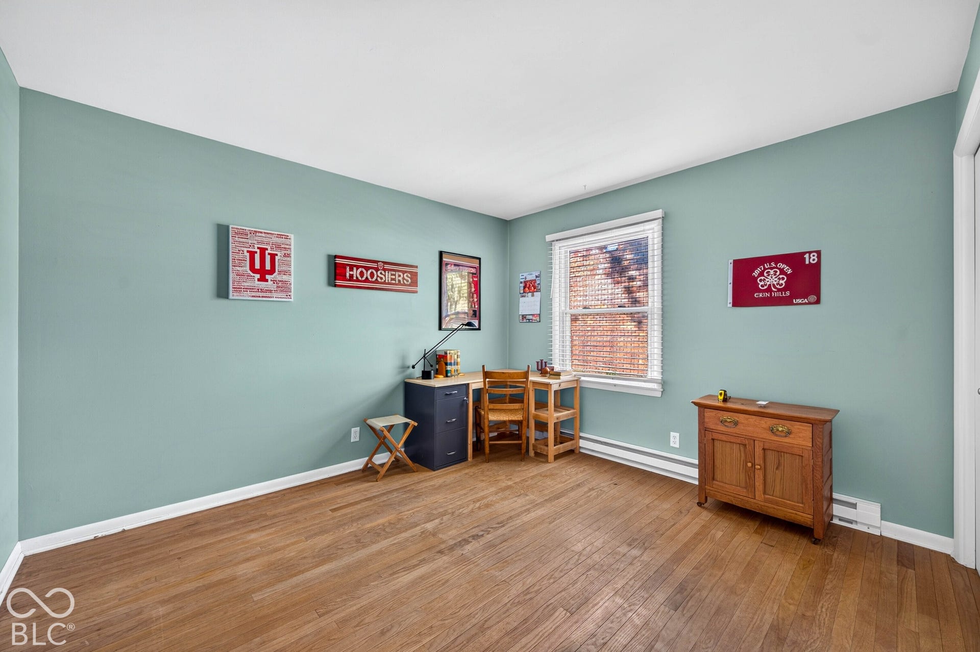 Room featuring wood-finish flooring, light blue wall paint, and white trim