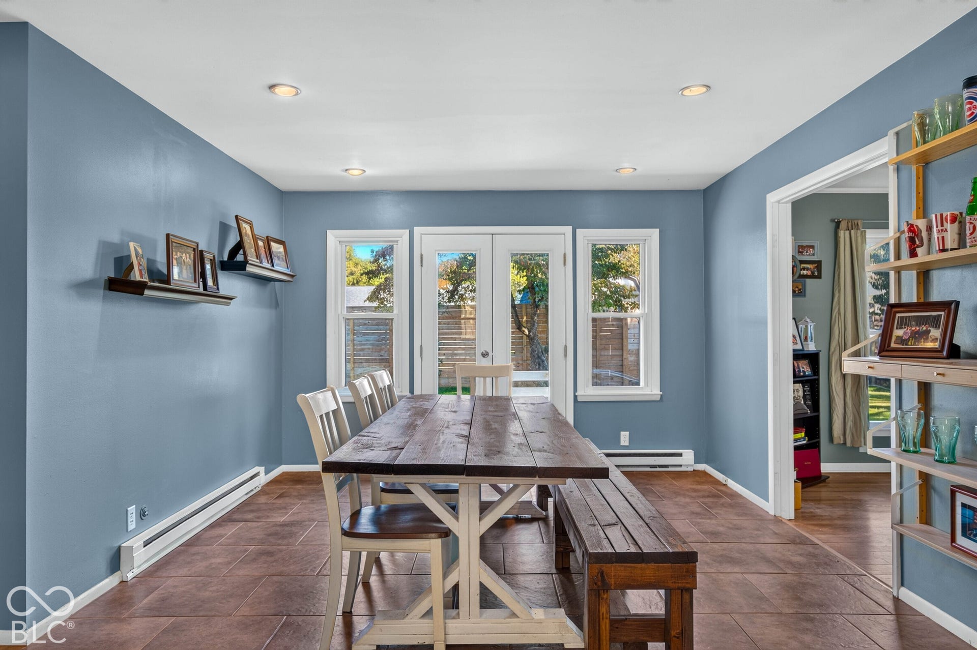 Recessed ceiling lighting, tiled flooring, built-in shelving, and two windows with double French doors