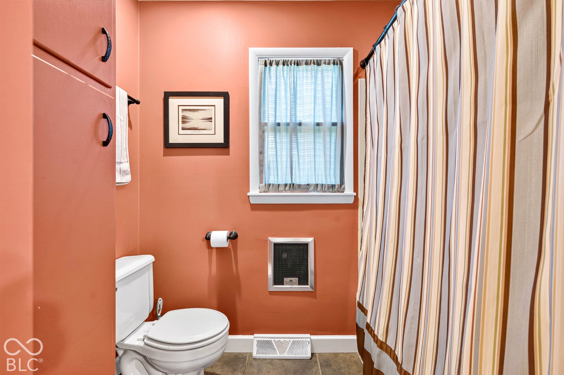Built-in cabinetry, white window trim, and white toilet