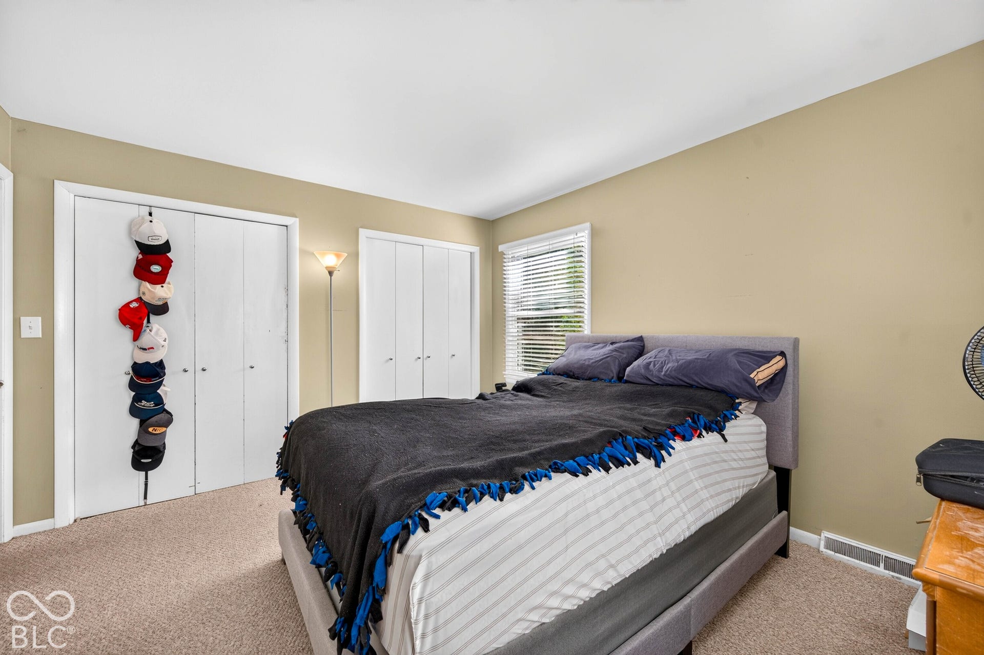 Two sets of double-door closets, wall-to-wall carpeting, and a window with blinds