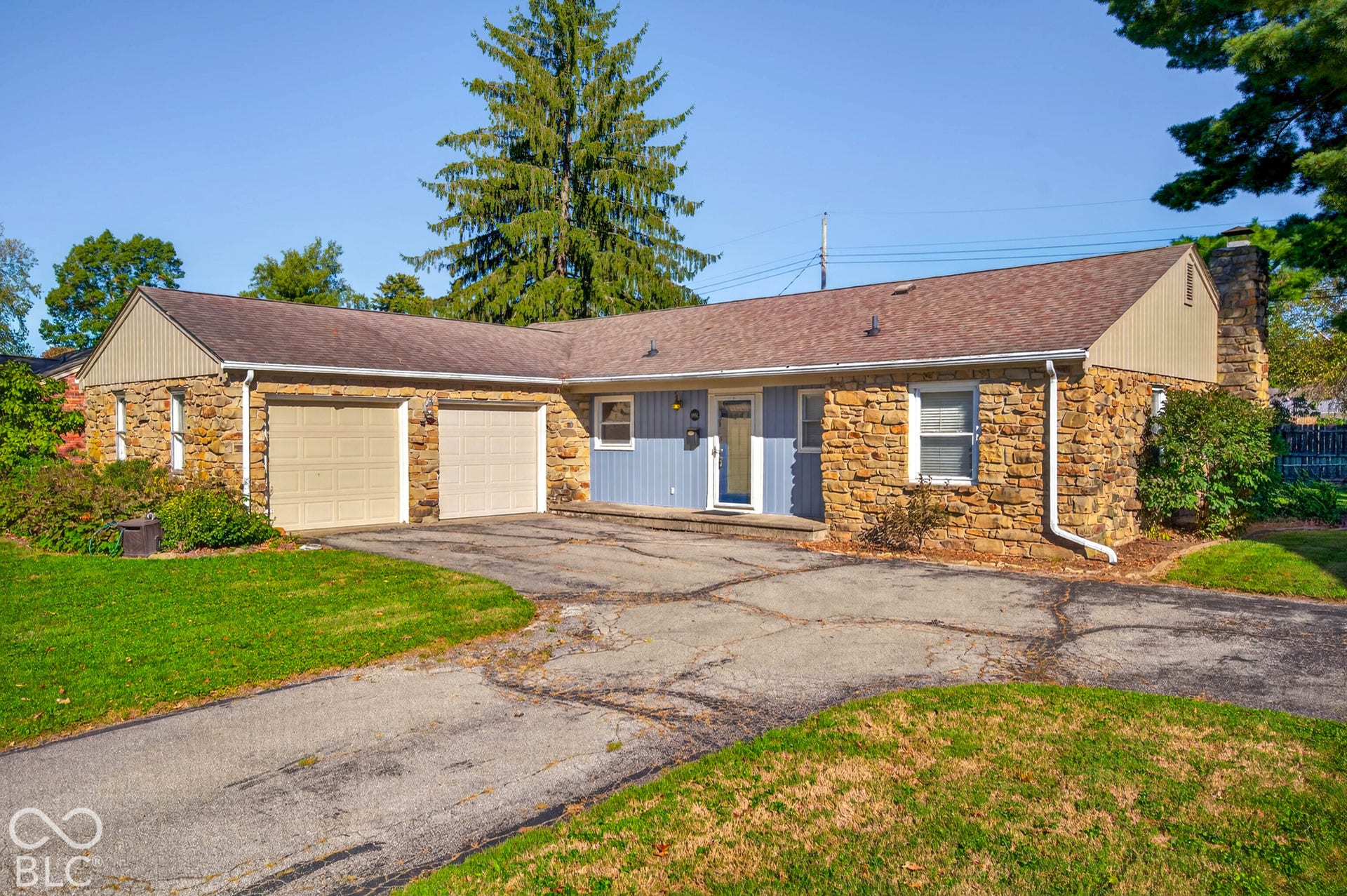 Stone facade with light blue siding accents and a two-car garage