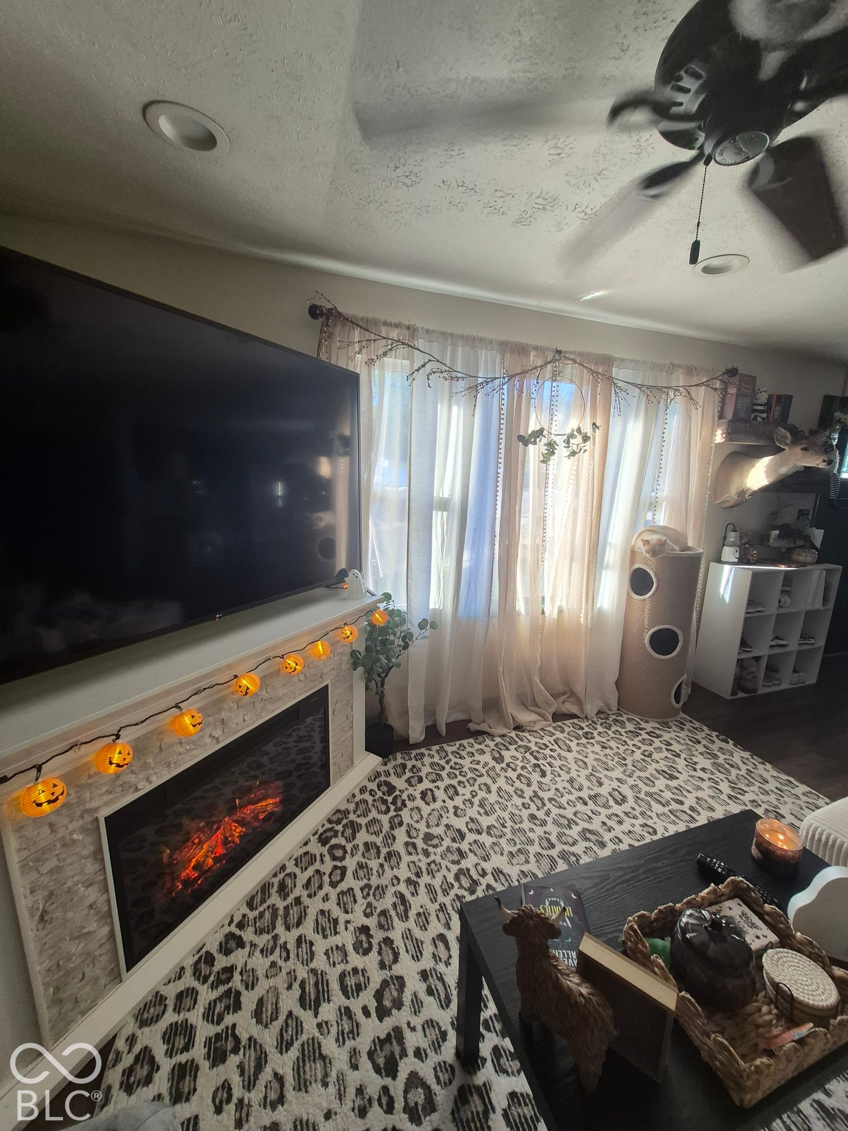 Recessed lighting, ceiling fan, and a built-in fireplace with a stone-finish facade