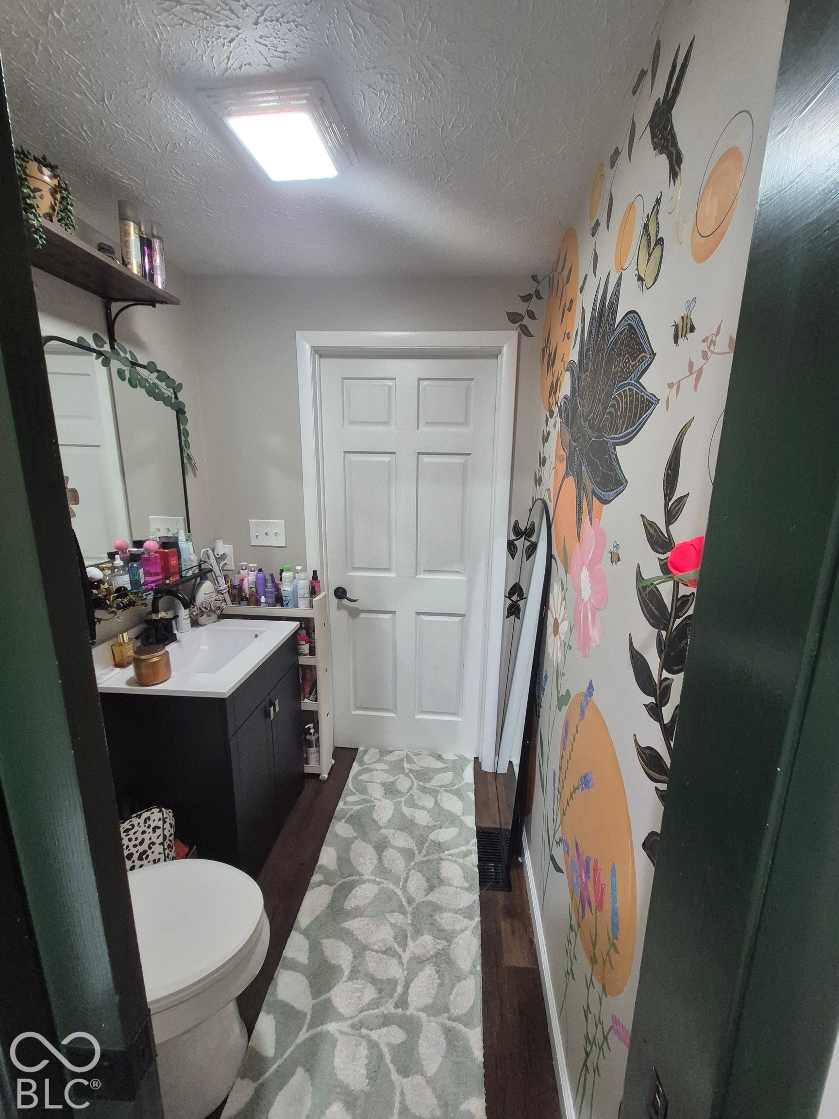 Wood-finish flooring, white paneled door, and recessed ceiling lighting