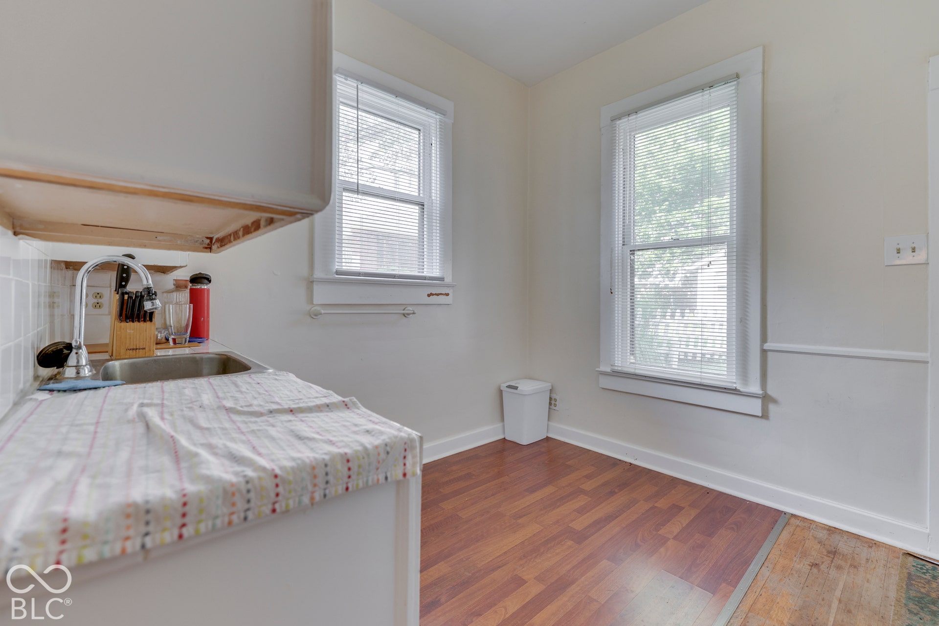 Unit 1 Wood-finish flooring with white baseboards and trim