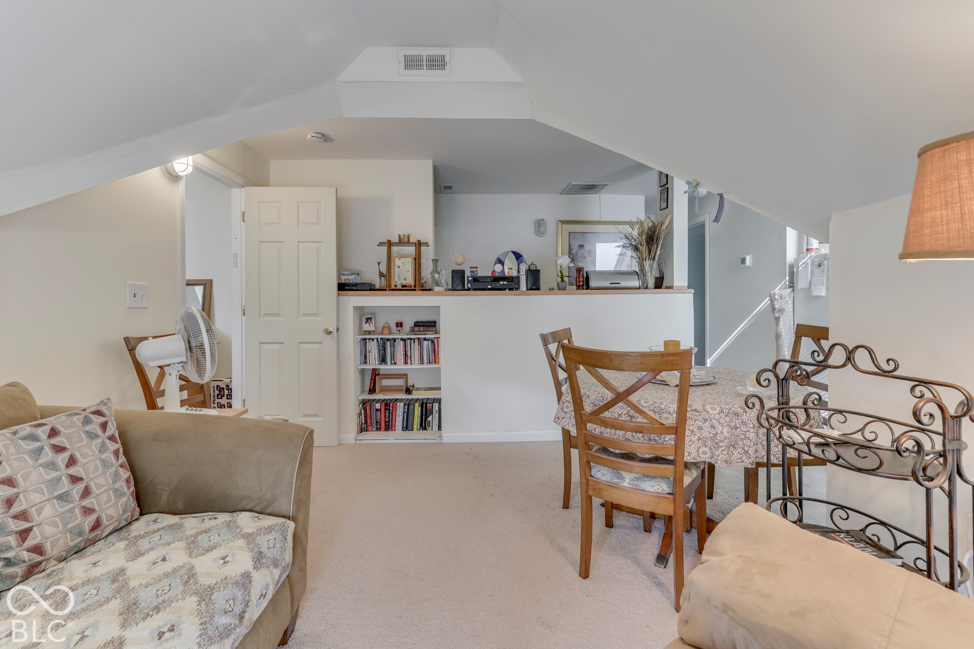 Integrated built-in shelving, carpeted flooring, and a half-wall partition