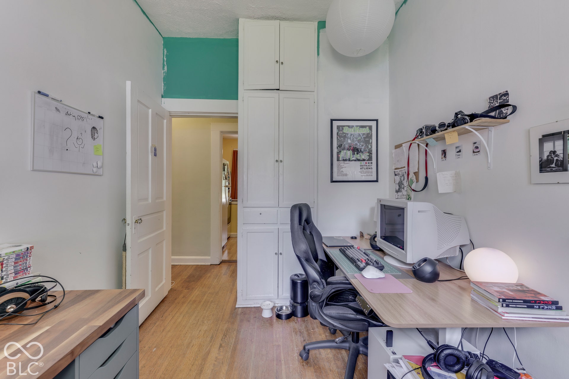 Unit 2 Wood-finish flooring with built-in cabinetry, a wall-mounted shelf, and a white interior door