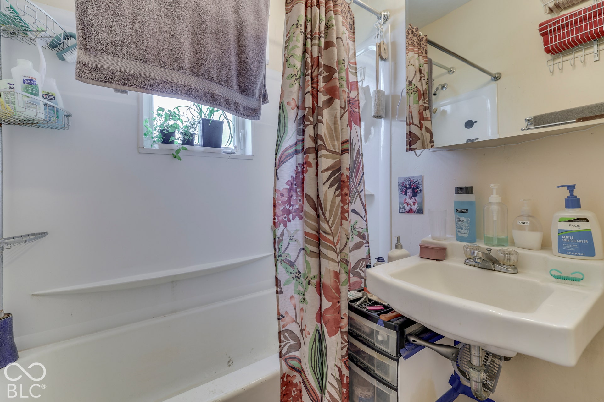 Unit 4 Bathroom wall-mounted sink with chrome faucet, integrated shelving, and an overhead wall shelf
