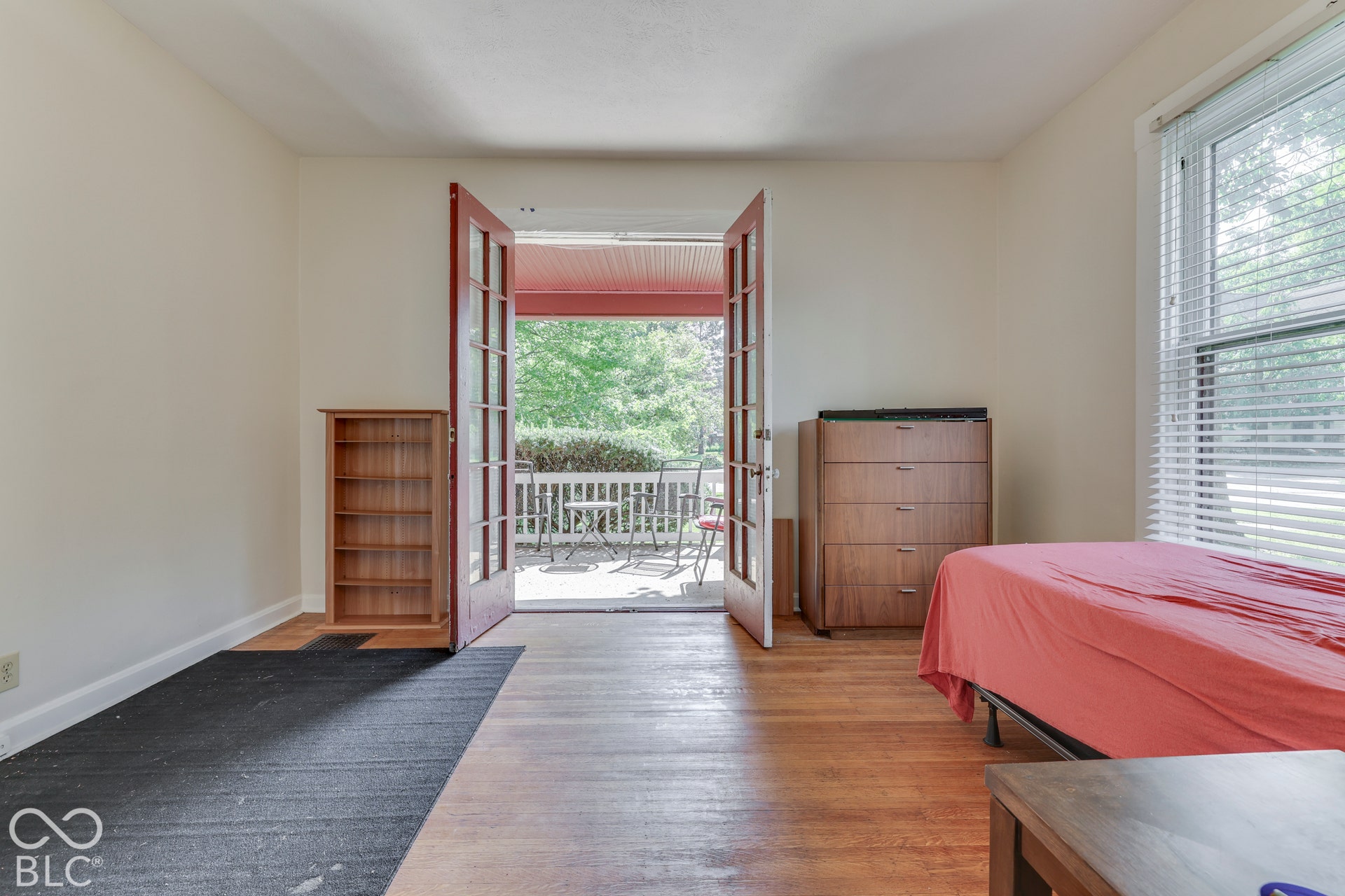 Unit 1 Hardwood flooring, white wall paint, double French doors, patio access, and a large window with blinds