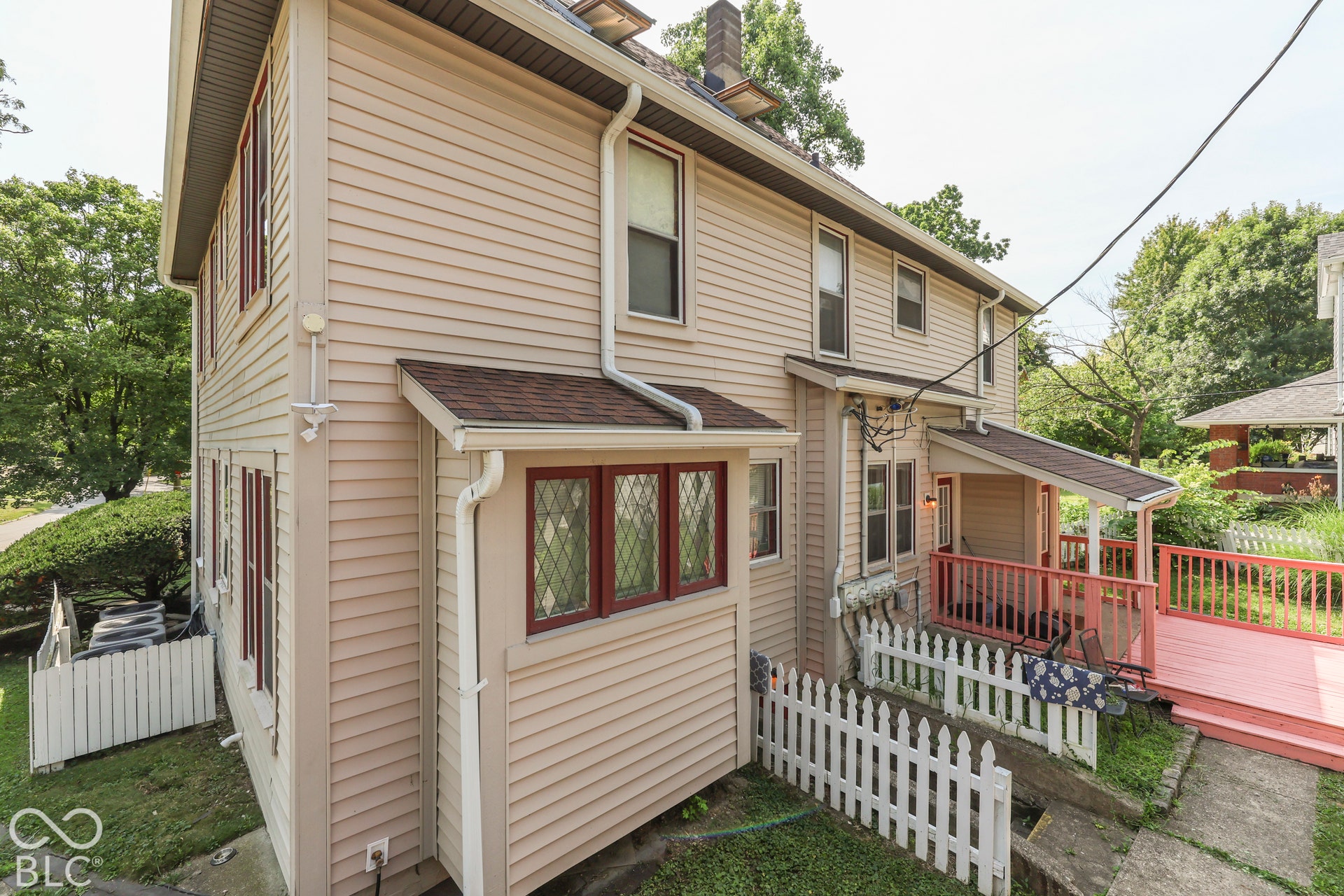 Two-story exterior with horizontal siding, decorative windows, covered porch, and an exterior deck.
