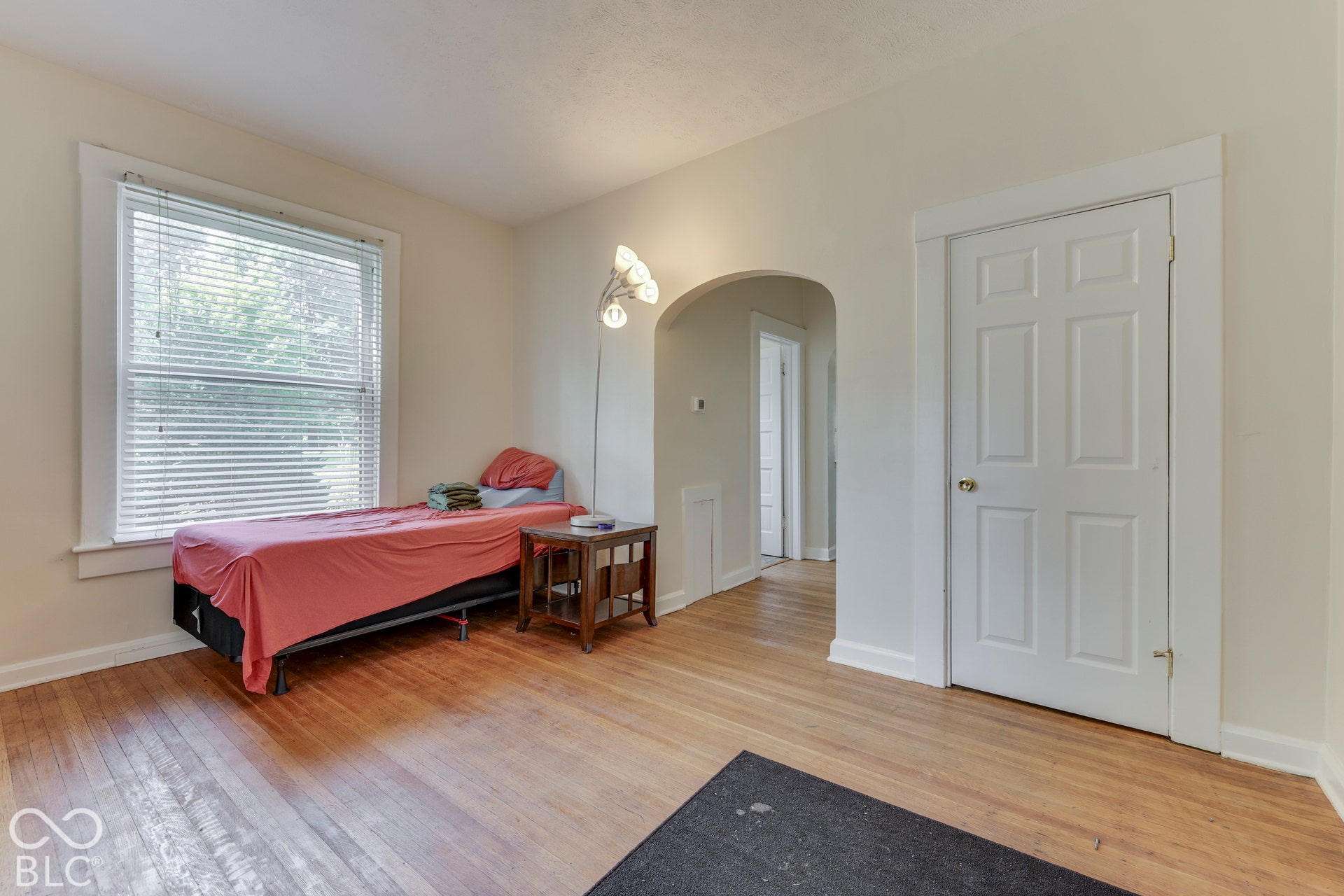Unit 1: Hardwood flooring, painted walls, white trim, arched doorway, and a single window