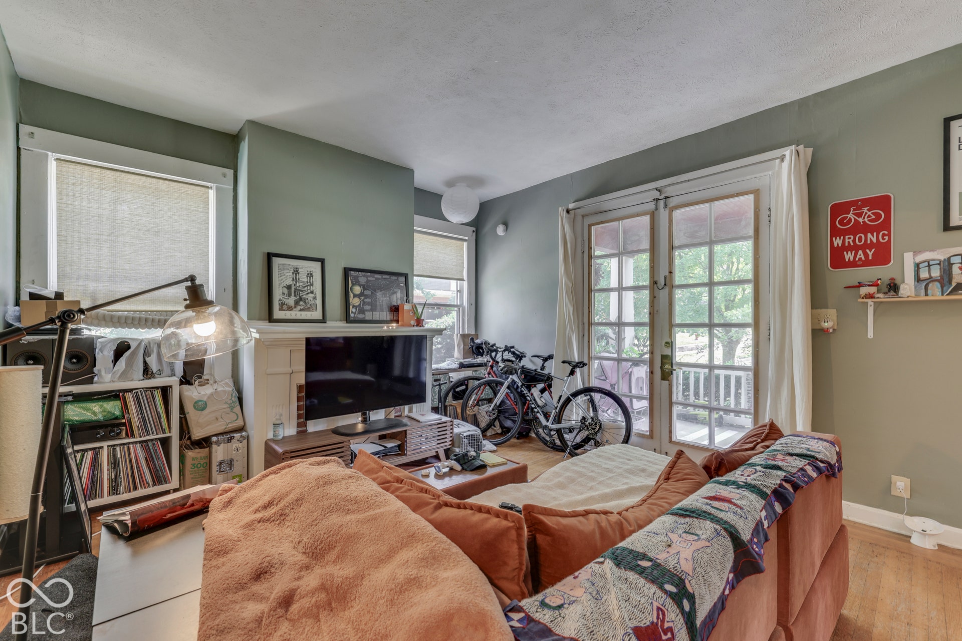 Unit 2 French doors with divided lites, hardwood flooring, and a decorative fireplace