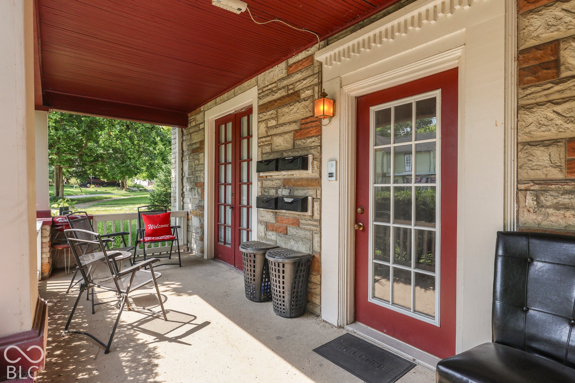 Covered porch with beautiful French doors and brick facade.