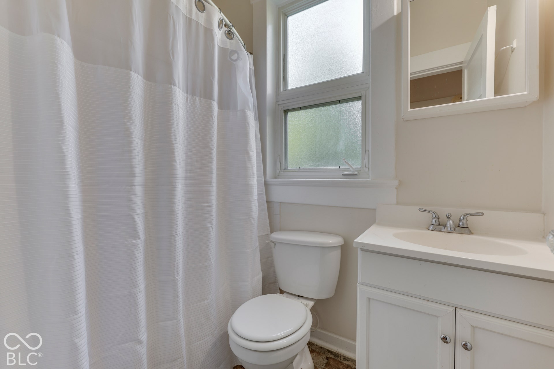 Unit 1 Single vanity with an integrated basin, chrome faucet, and white cabinetry