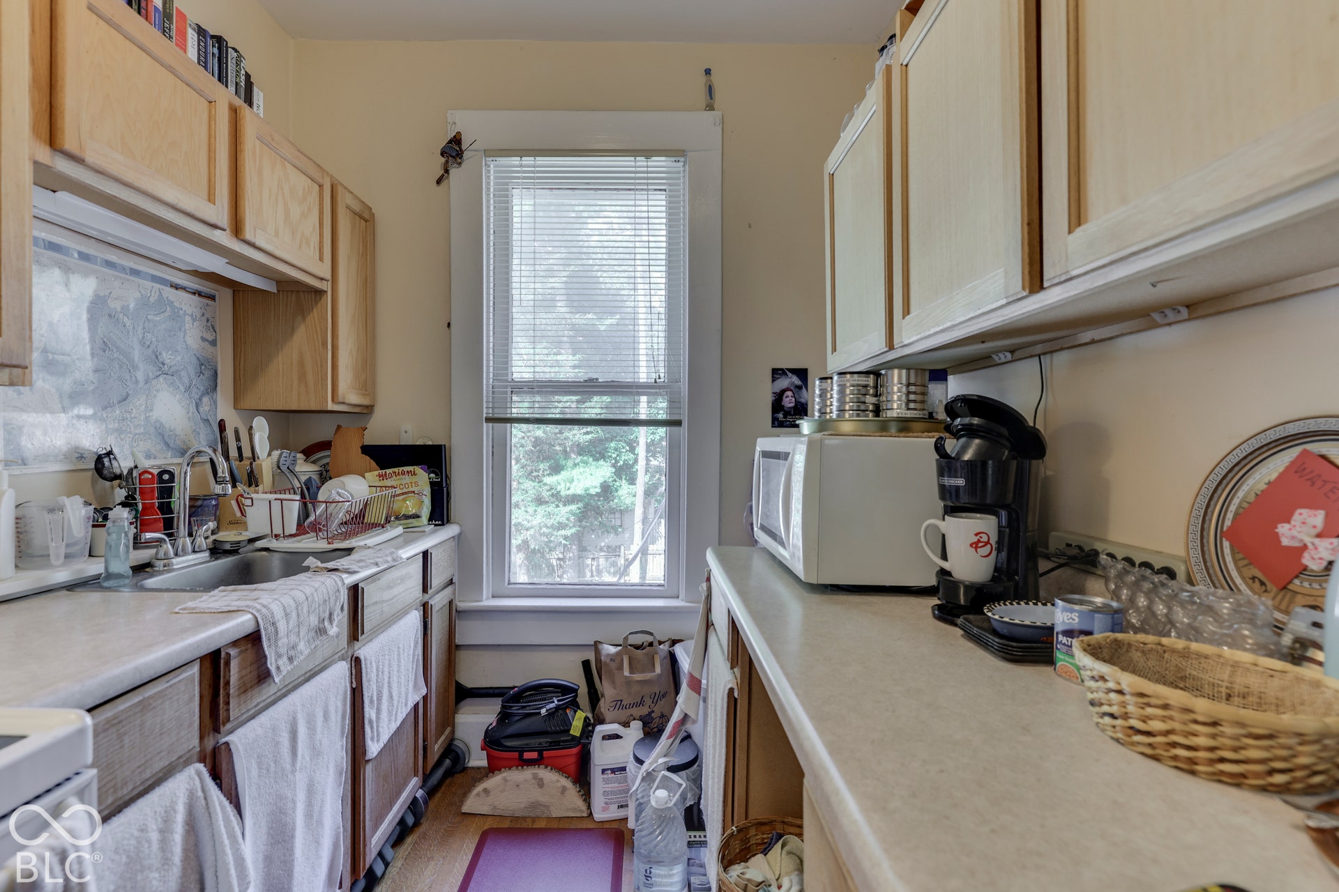 Unit 4 Wood-finish cabinetry paired with white countertops and a stainless steel sink
