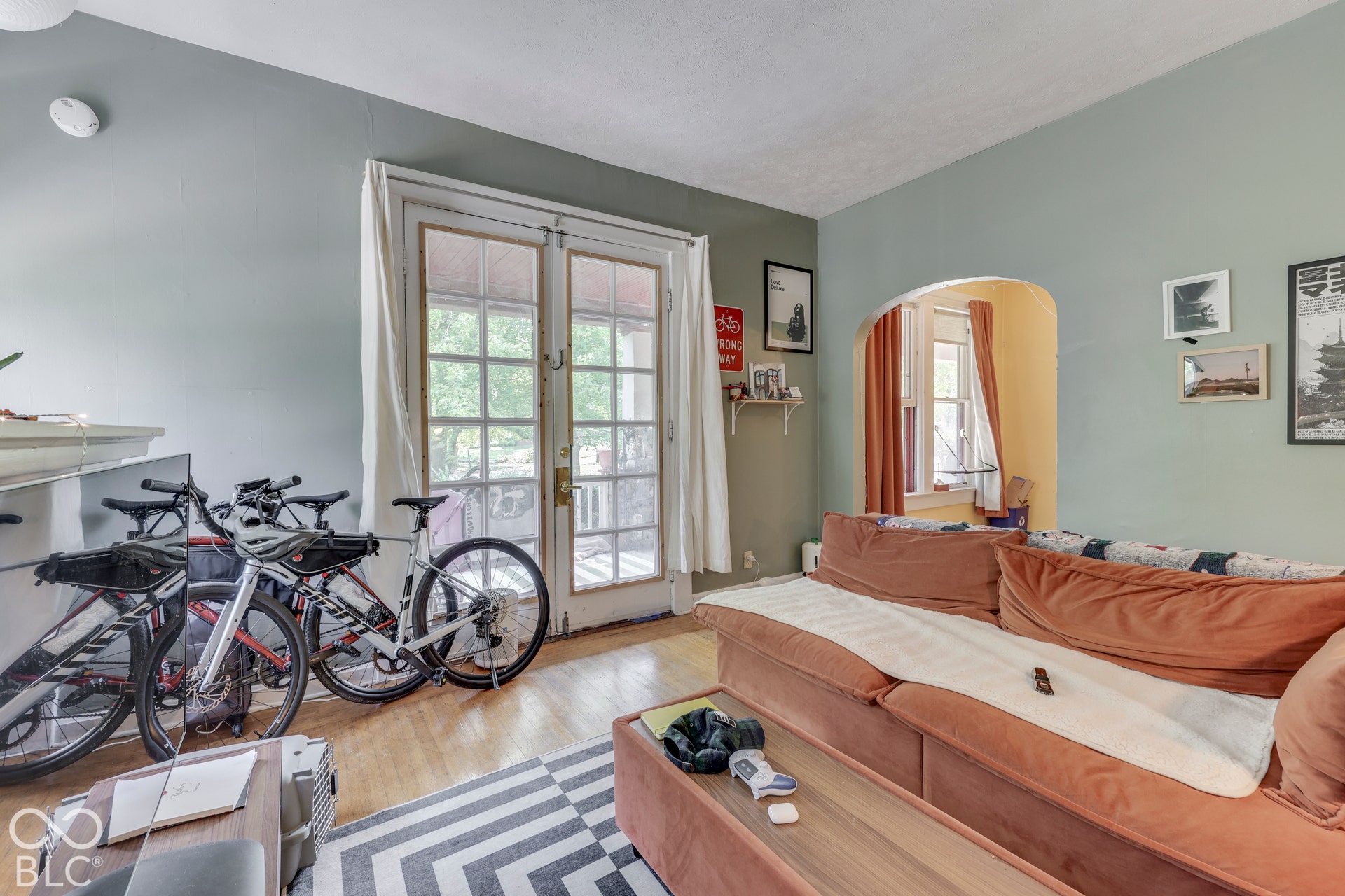 Unit 2 Hardwood flooring, arched doorway, and double French doors with transom windows