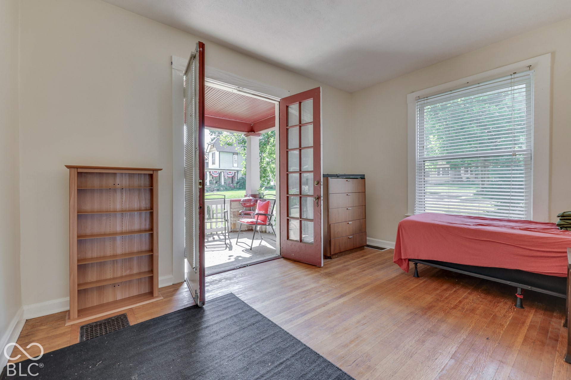Unit 1 Hardwood flooring, white walls, and a large window with blinds