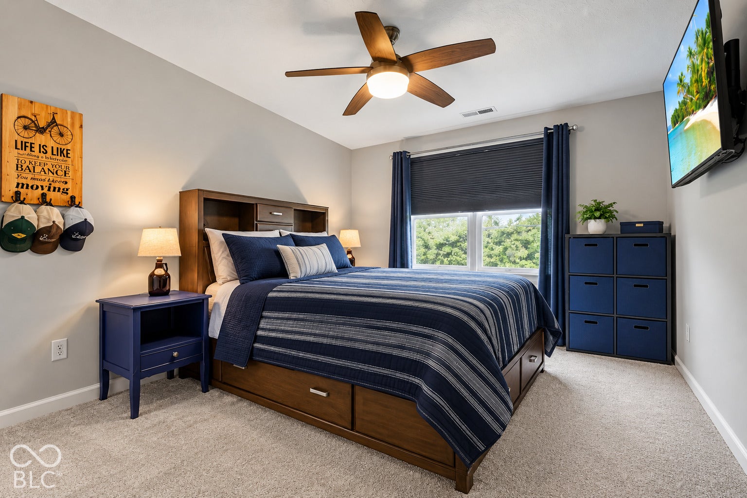 Carpeted flooring, a window with roller shade, and a ceiling fan with integrated lighting
