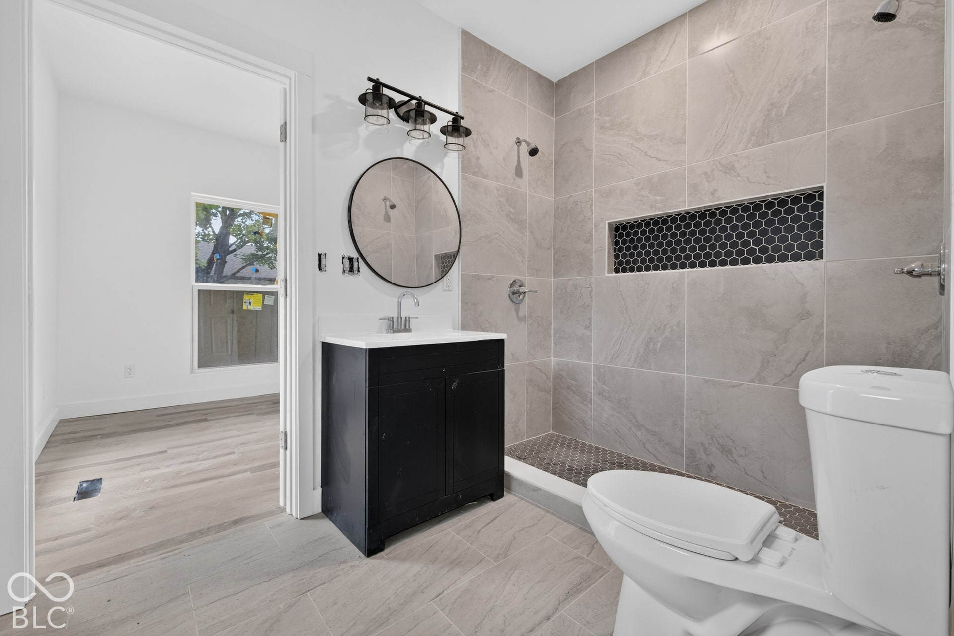 Black vanity with a white countertop and round mirror