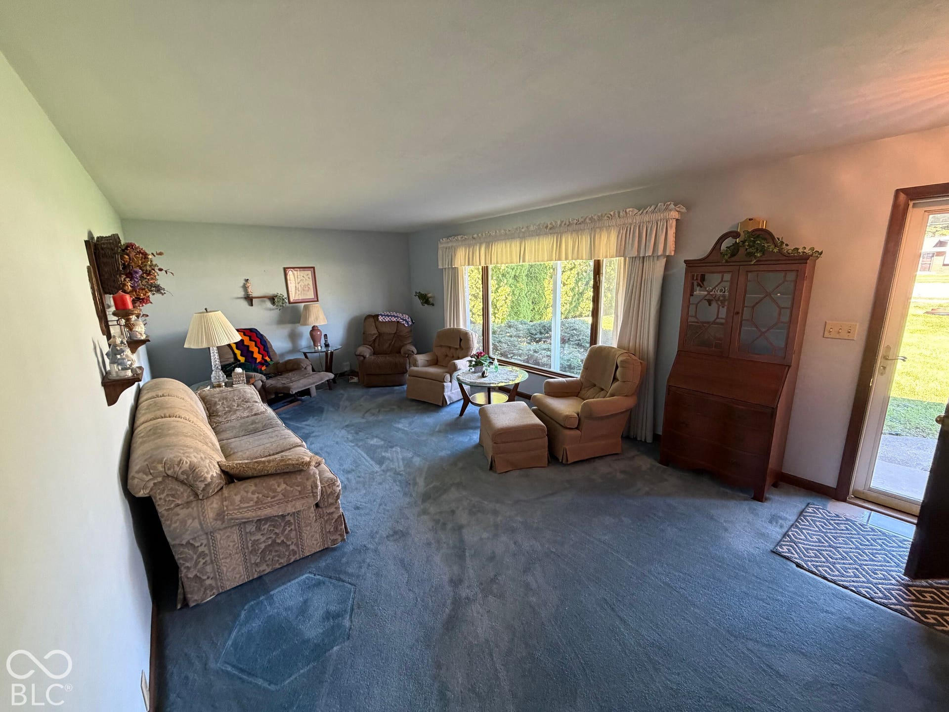 Expansive window with a valance, light-colored walls, and carpeting throughout