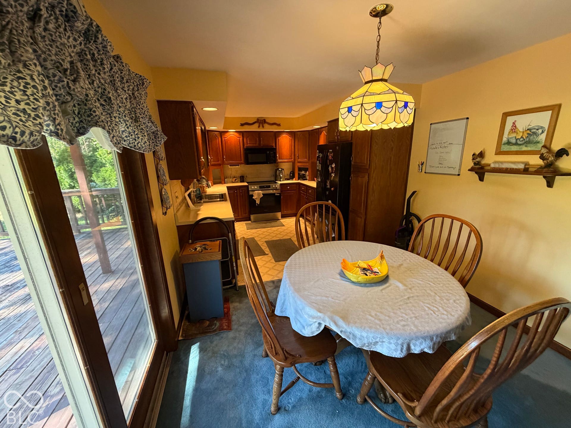 Kitchen featuring wood cabinetry, light countertops, and tile flooring, with an adjacent dining area