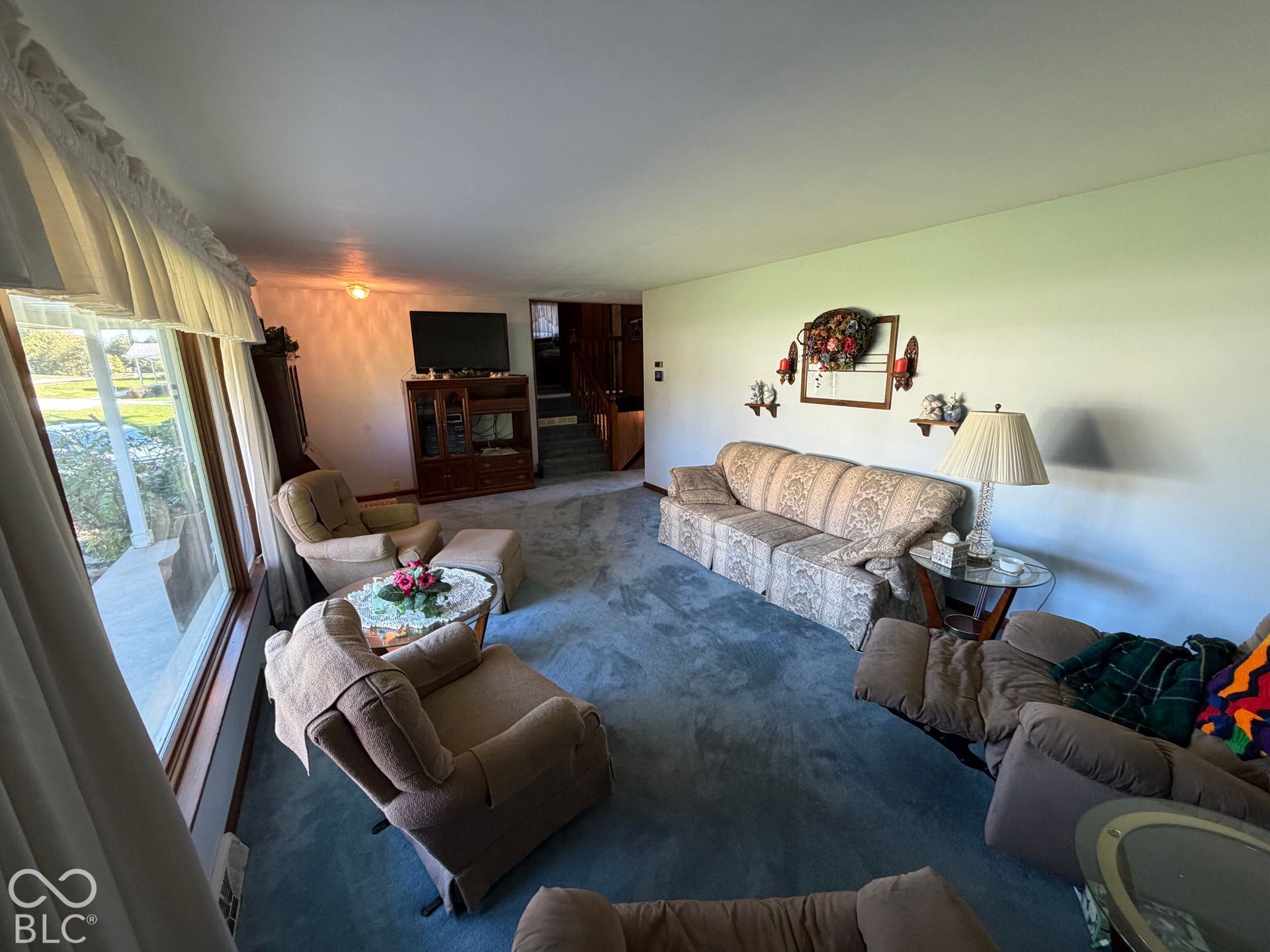 Large window, carpeted flooring, white walls, recessed ceiling light