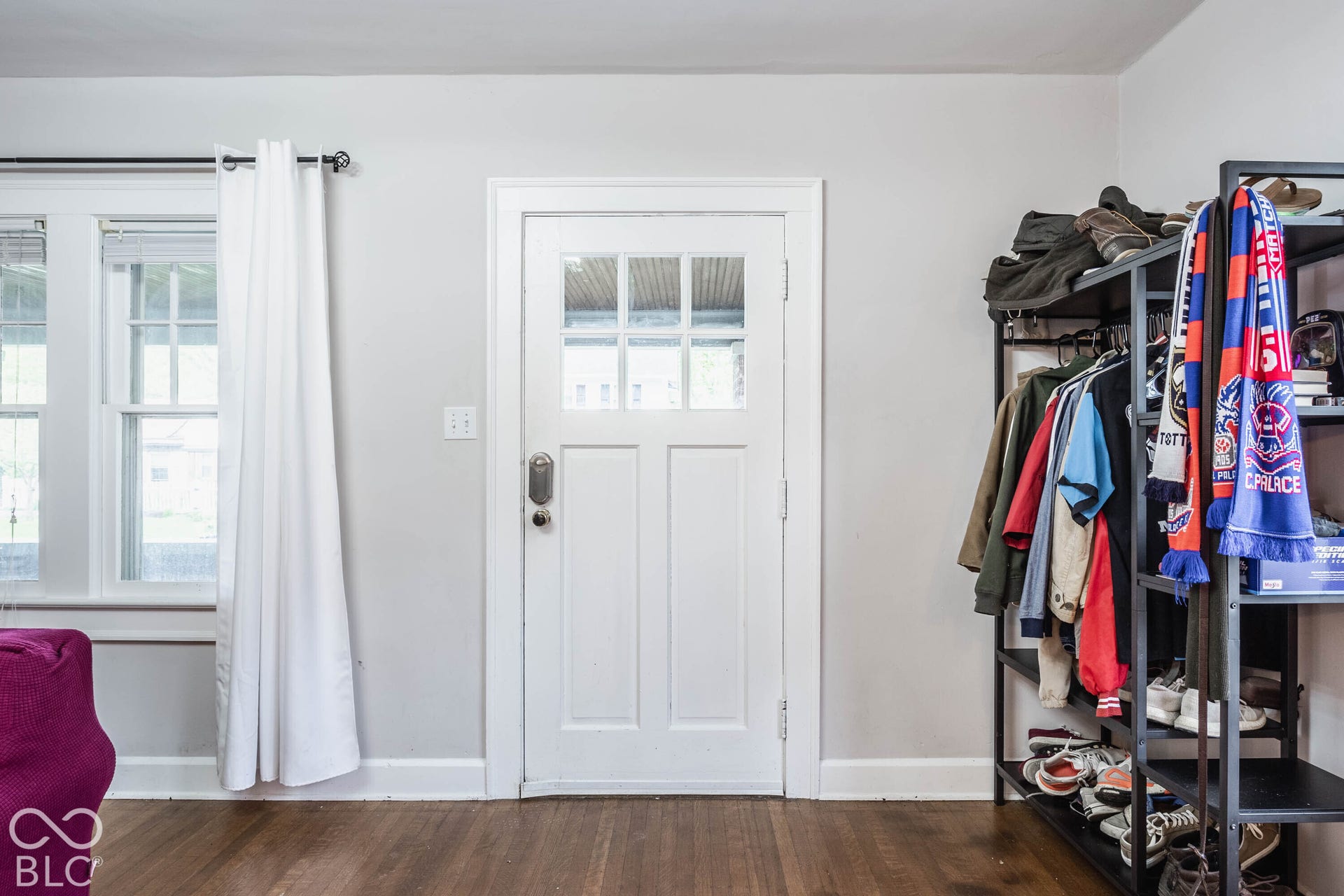 Bright entry foyer with French doors featuring multiple glass panes, white trim, and wood-finish flooring throughout