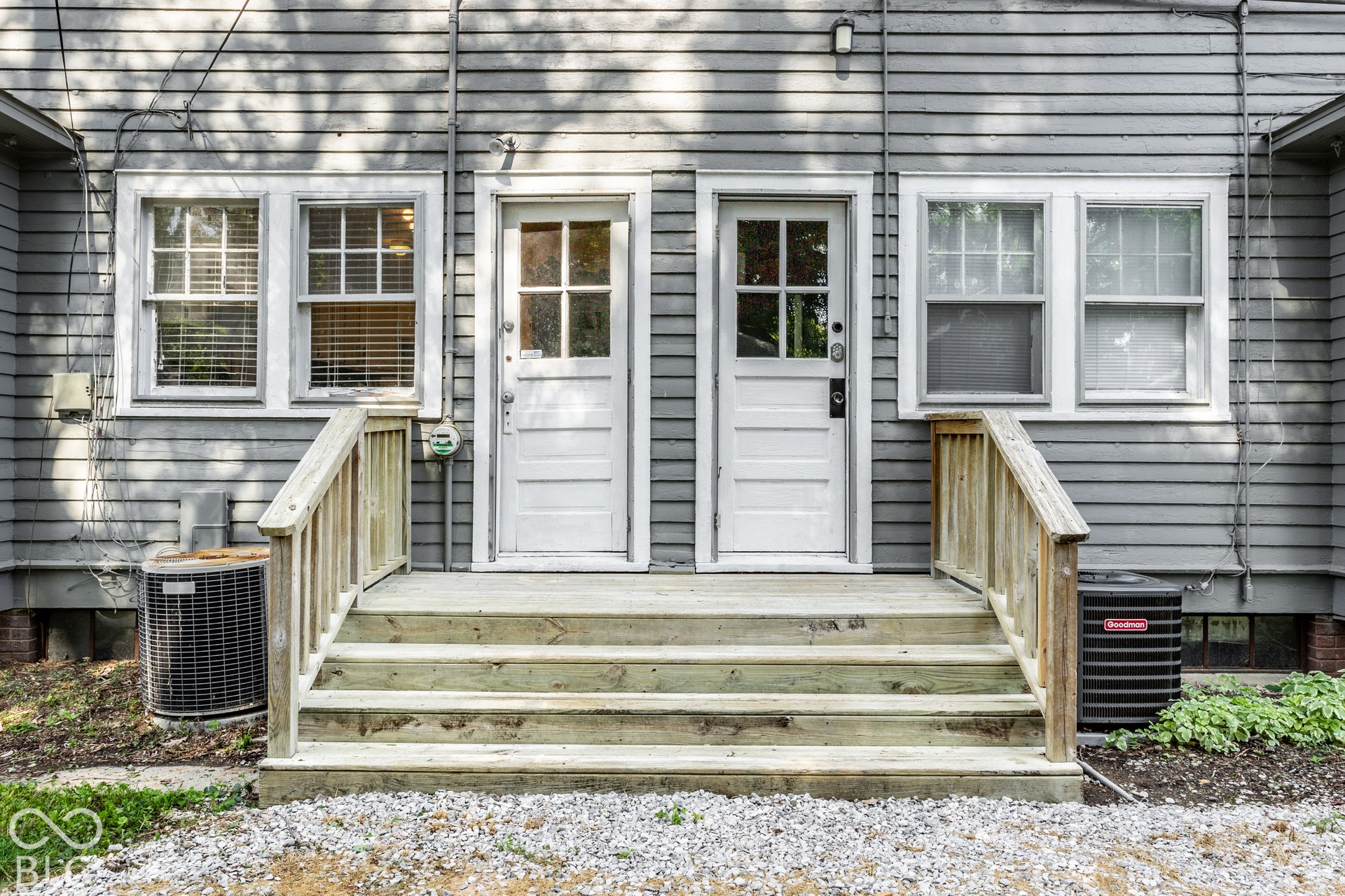 Dual entry doors with multi-pane windows and wood steps