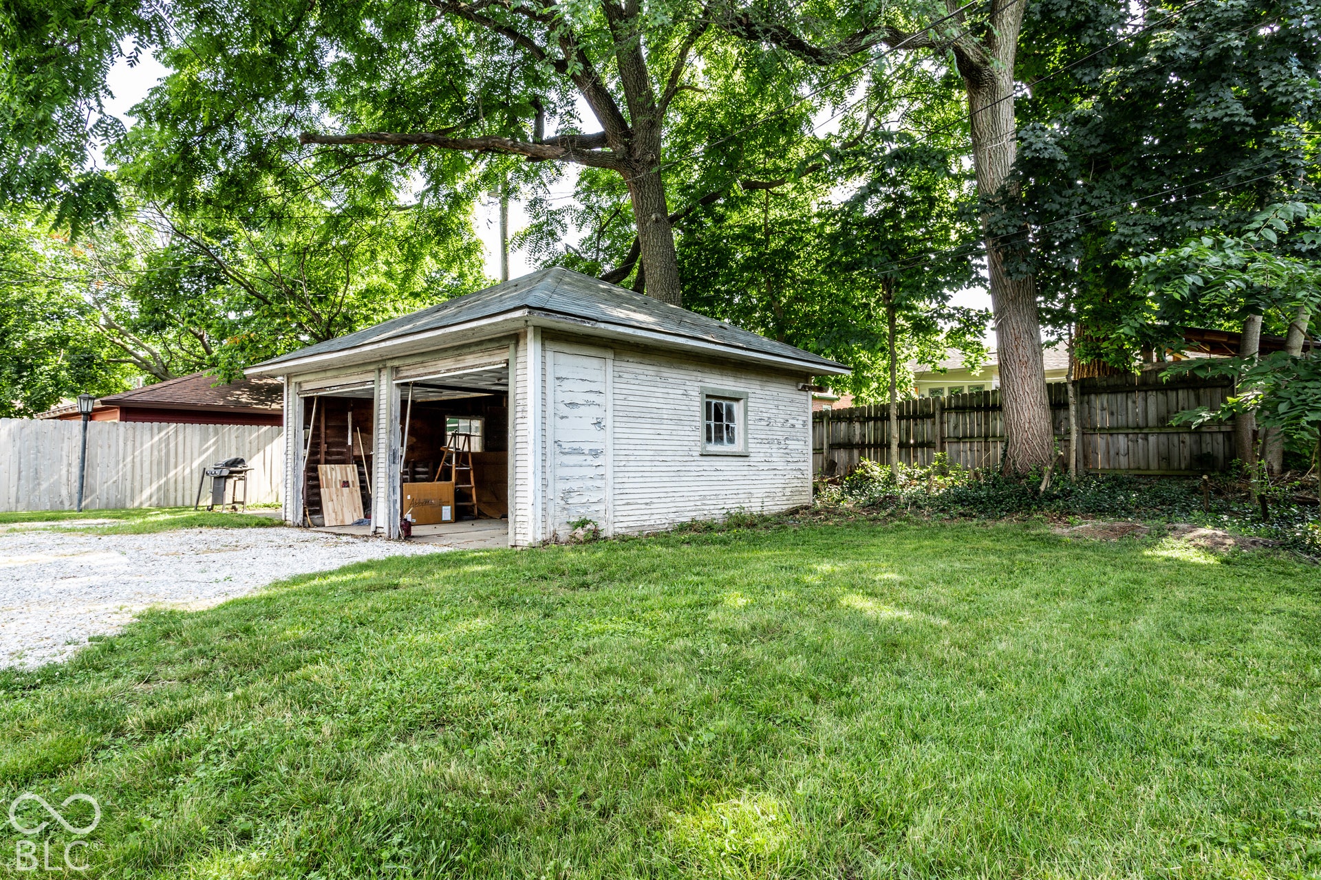 Detached two-car garage with white paneled doors and a side window
