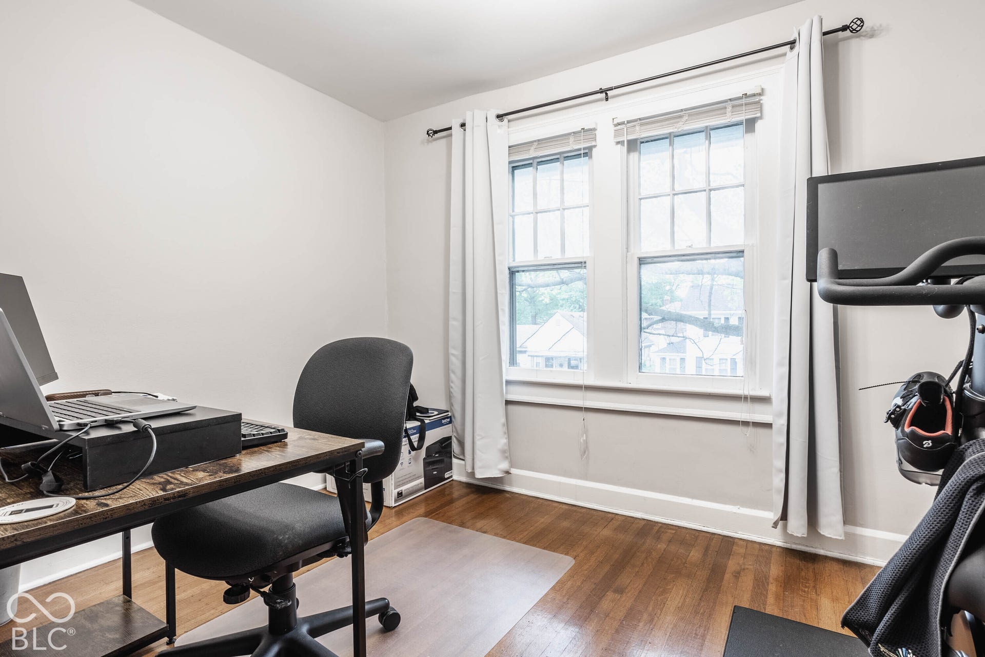 Hardwood flooring, painted walls, and window with casing