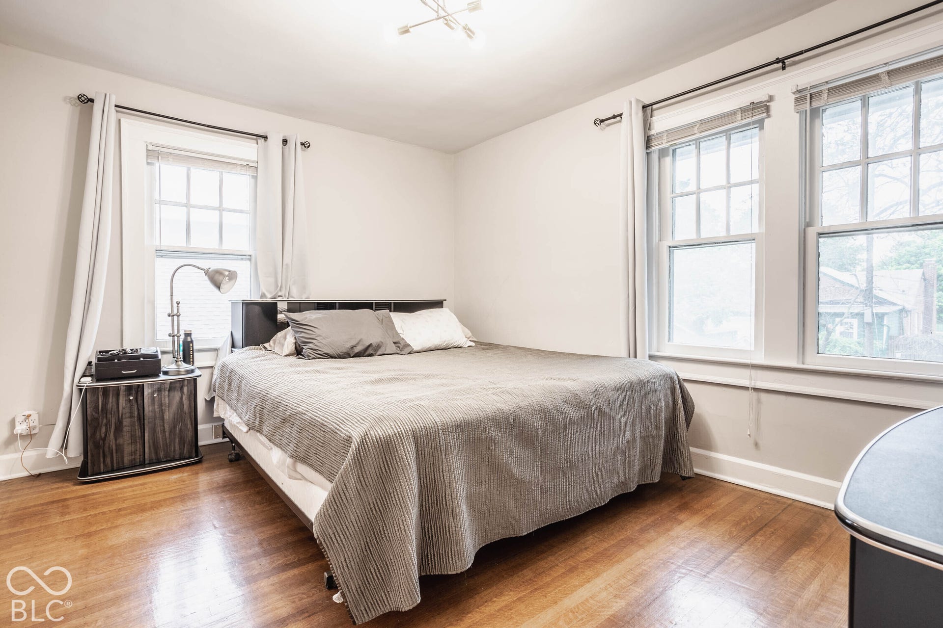 Hardwood flooring, multiple sash windows, overhead lighting, and light-toned walls