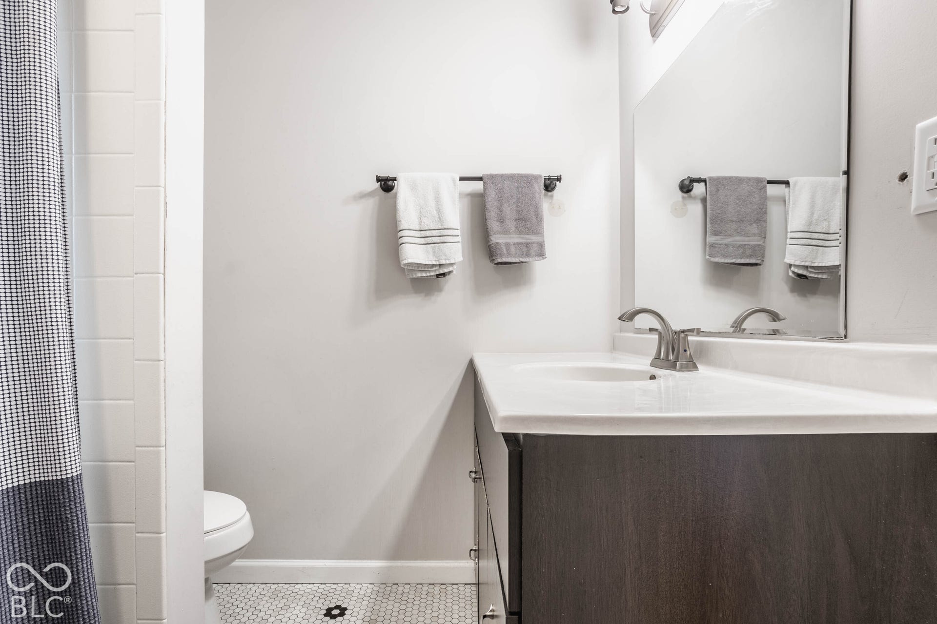 Vanity with white countertop, undermount sink, and brushed nickel faucet