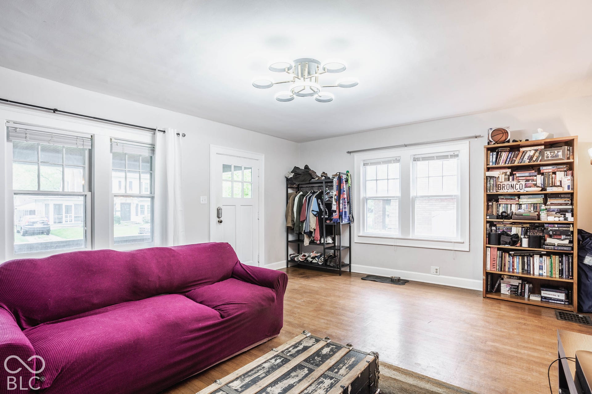 Light wood-finish flooring, multiple windows providing natural light, and a modern ceiling light fixture