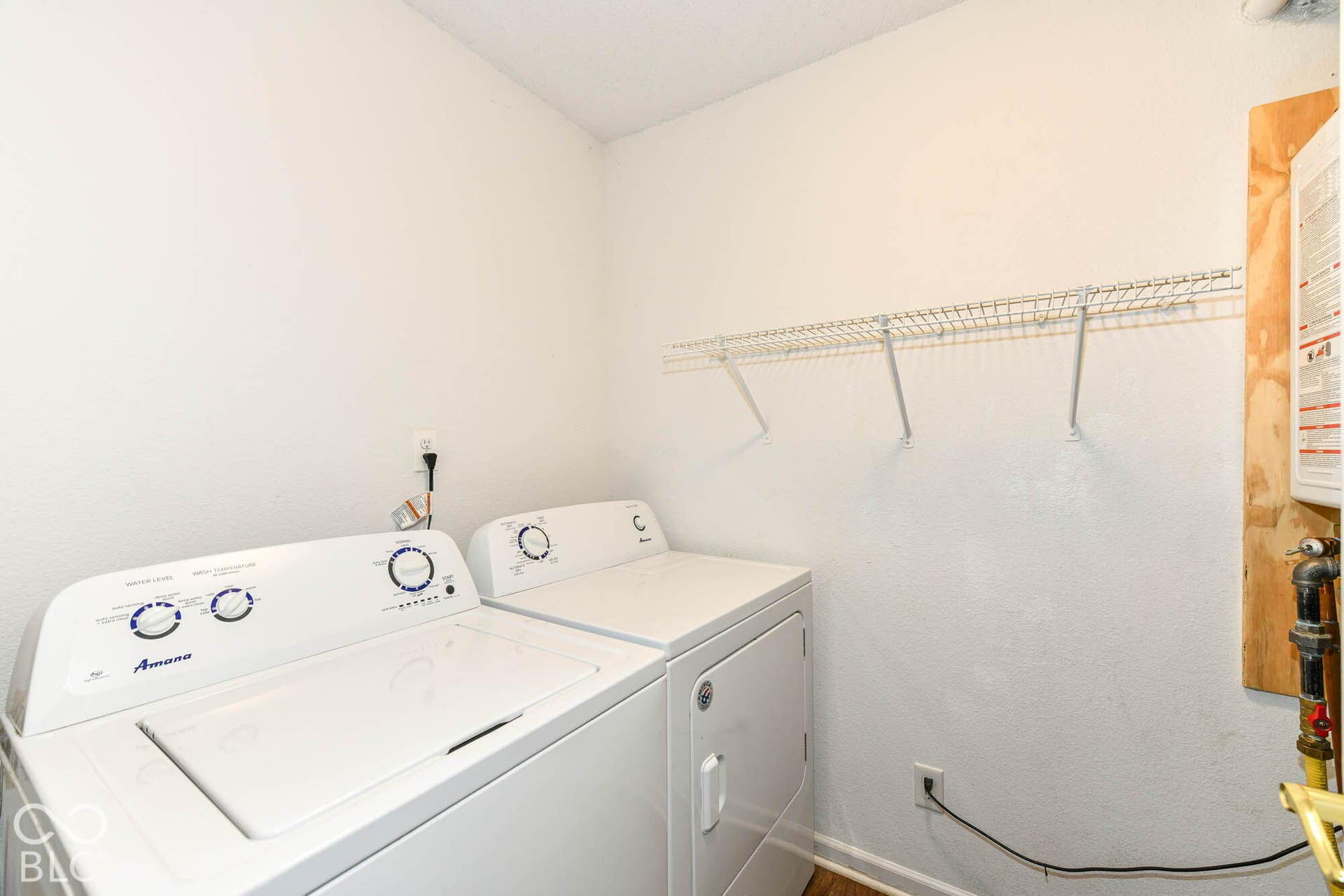 Laundry area featuring a top-load washing machine, front-load dryer, and wire shelving