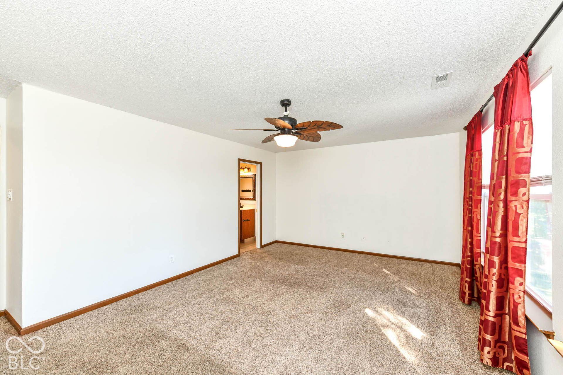 Carpeted flooring, white walls, and a ceiling fan with integrated lighting