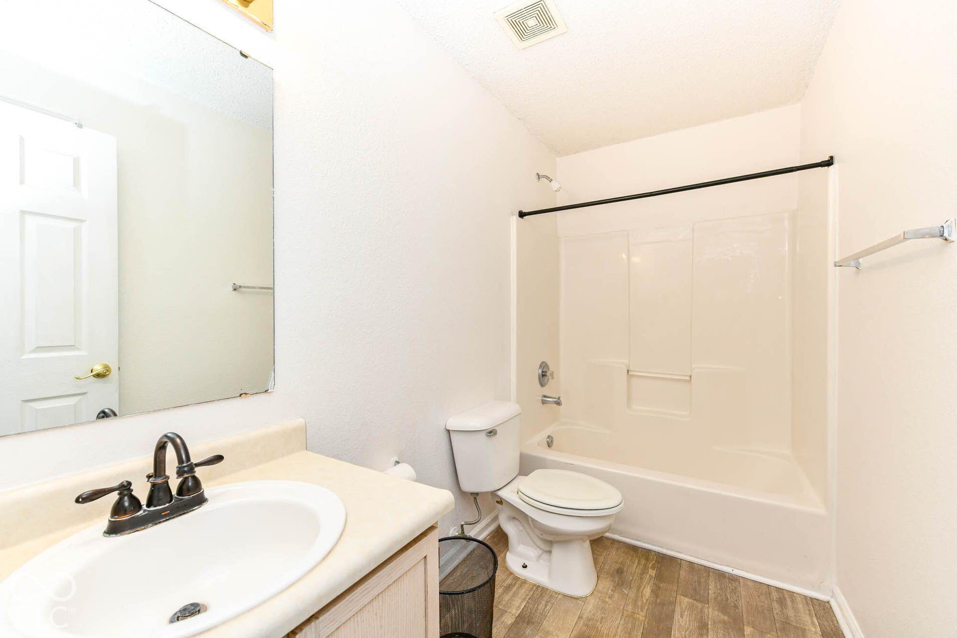 Bathroom featuring a single vanity, undermount sink, dark bronze faucet, and wood-finish flooring