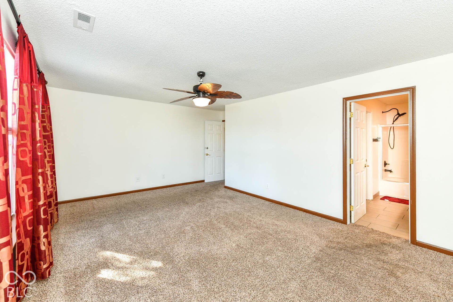 Neutral-toned carpeting, white walls, and a ceiling fan with integrated lighting