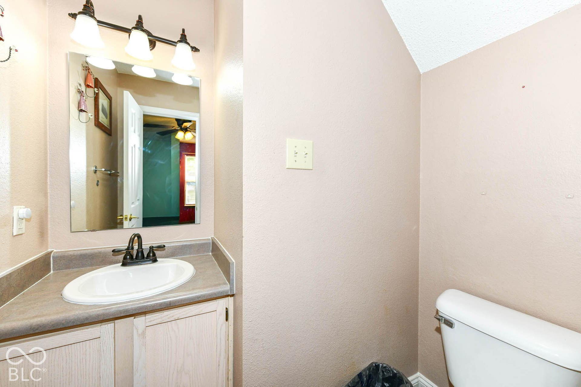 Recessed vanity with an oval basin sink, dark-toned faucet, and a large wall-mounted mirror