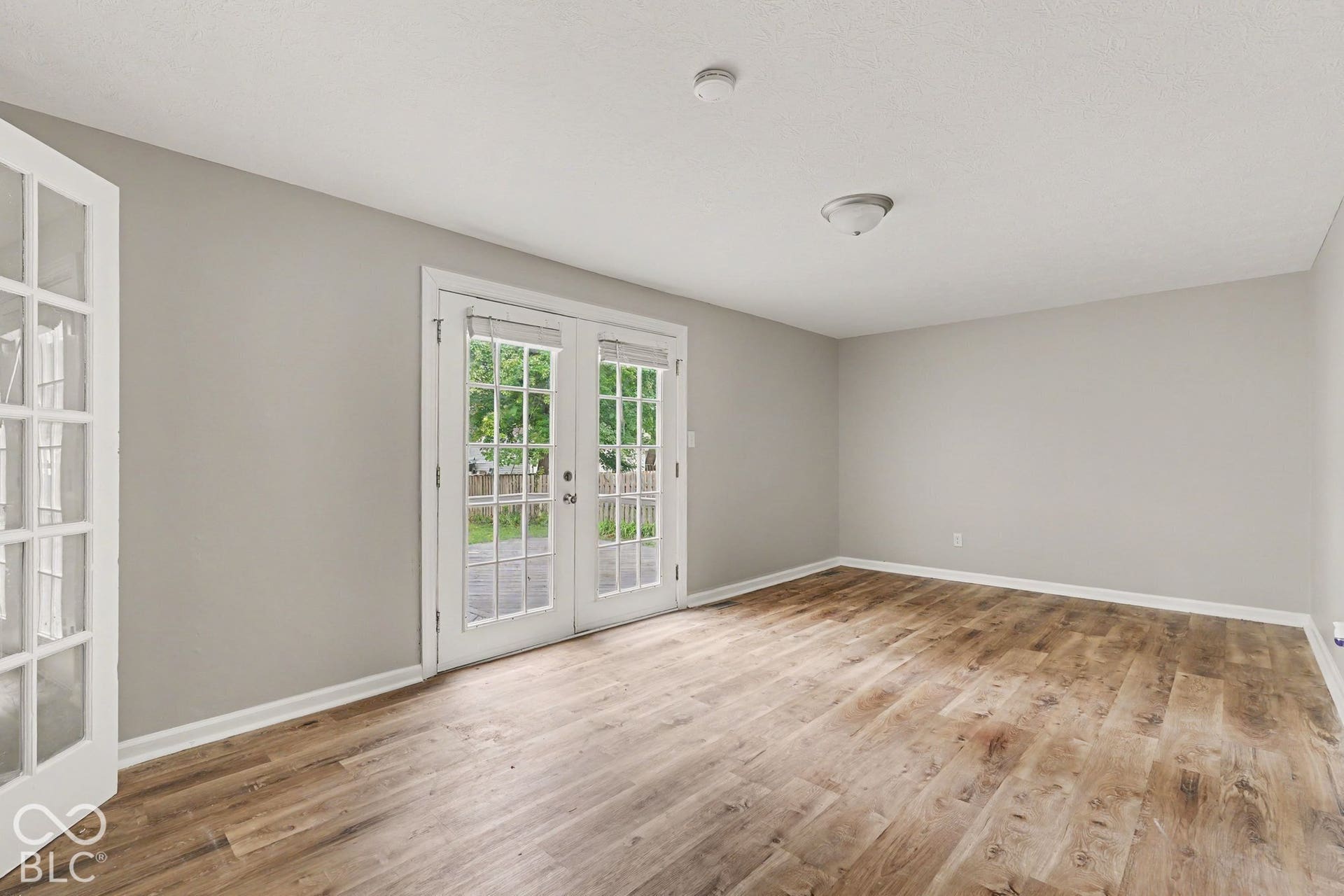 Wood-finish flooring throughout, light gray wall paint, and white trim