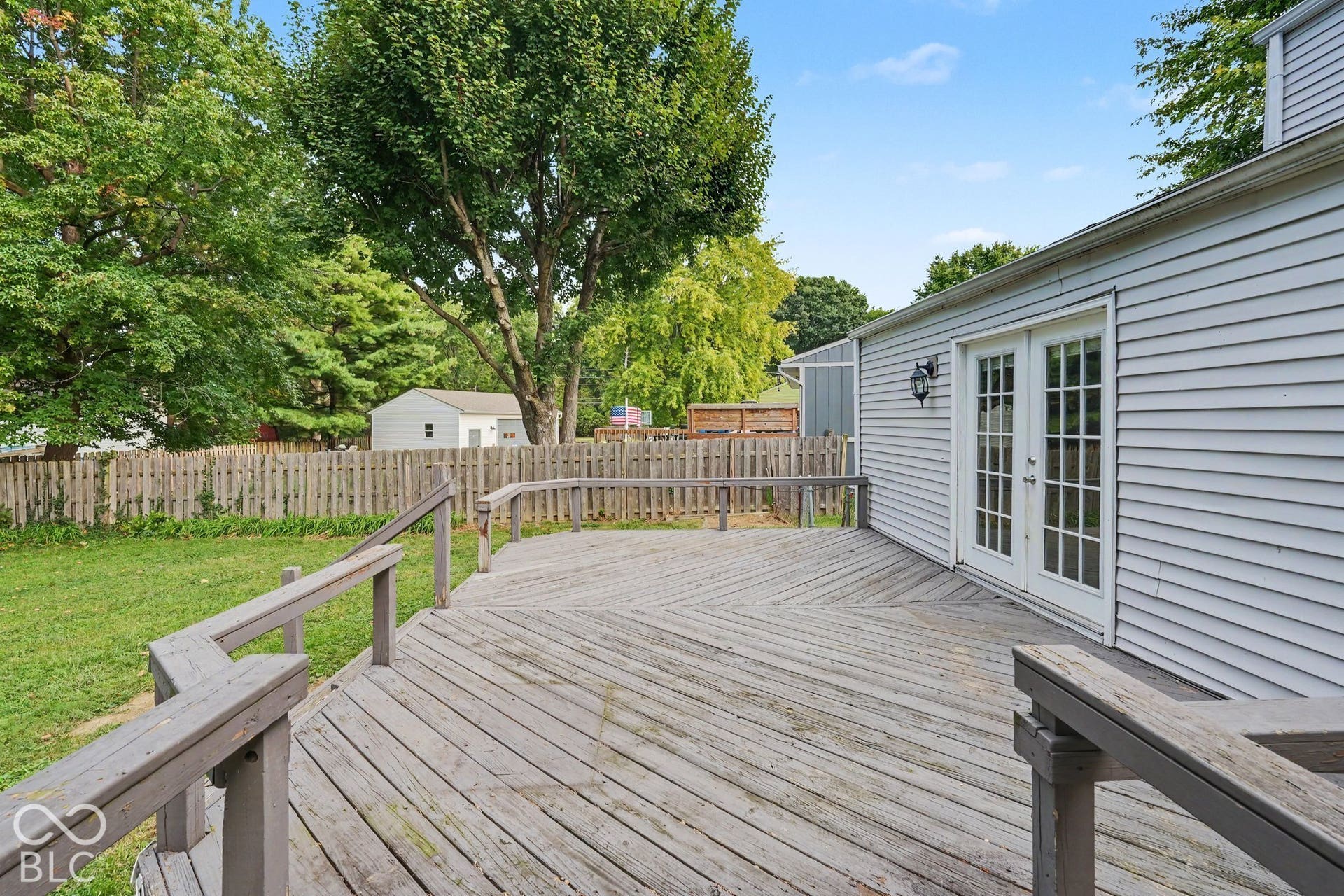 Expansive wooden deck with a geometric pattern, complete with railings
