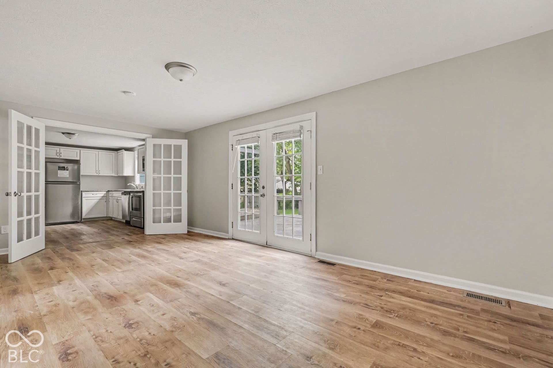 Wood-finish flooring, light gray wall tones, and white trim