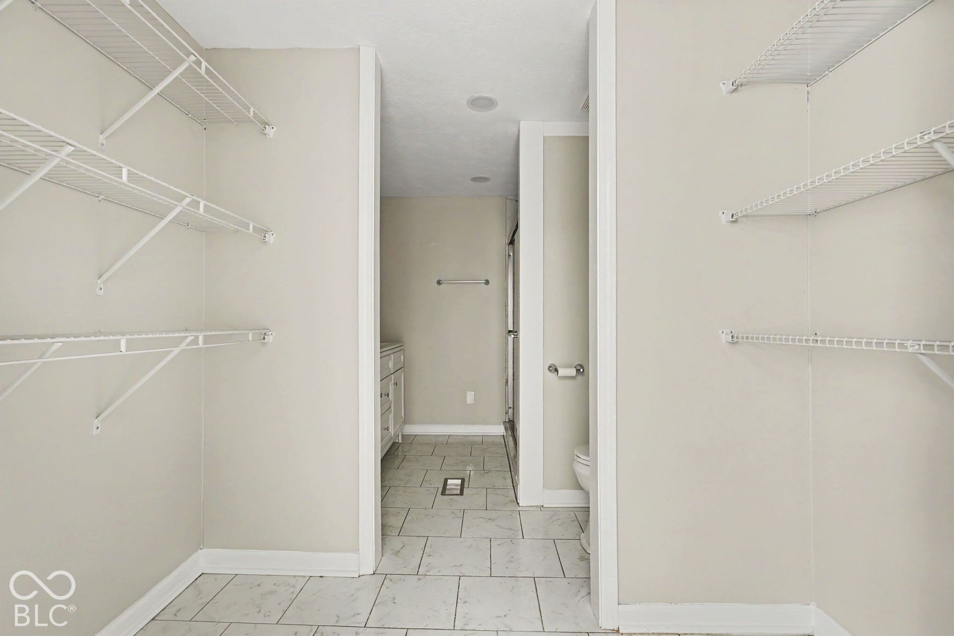 Open concept closet with wire shelving and tile flooring