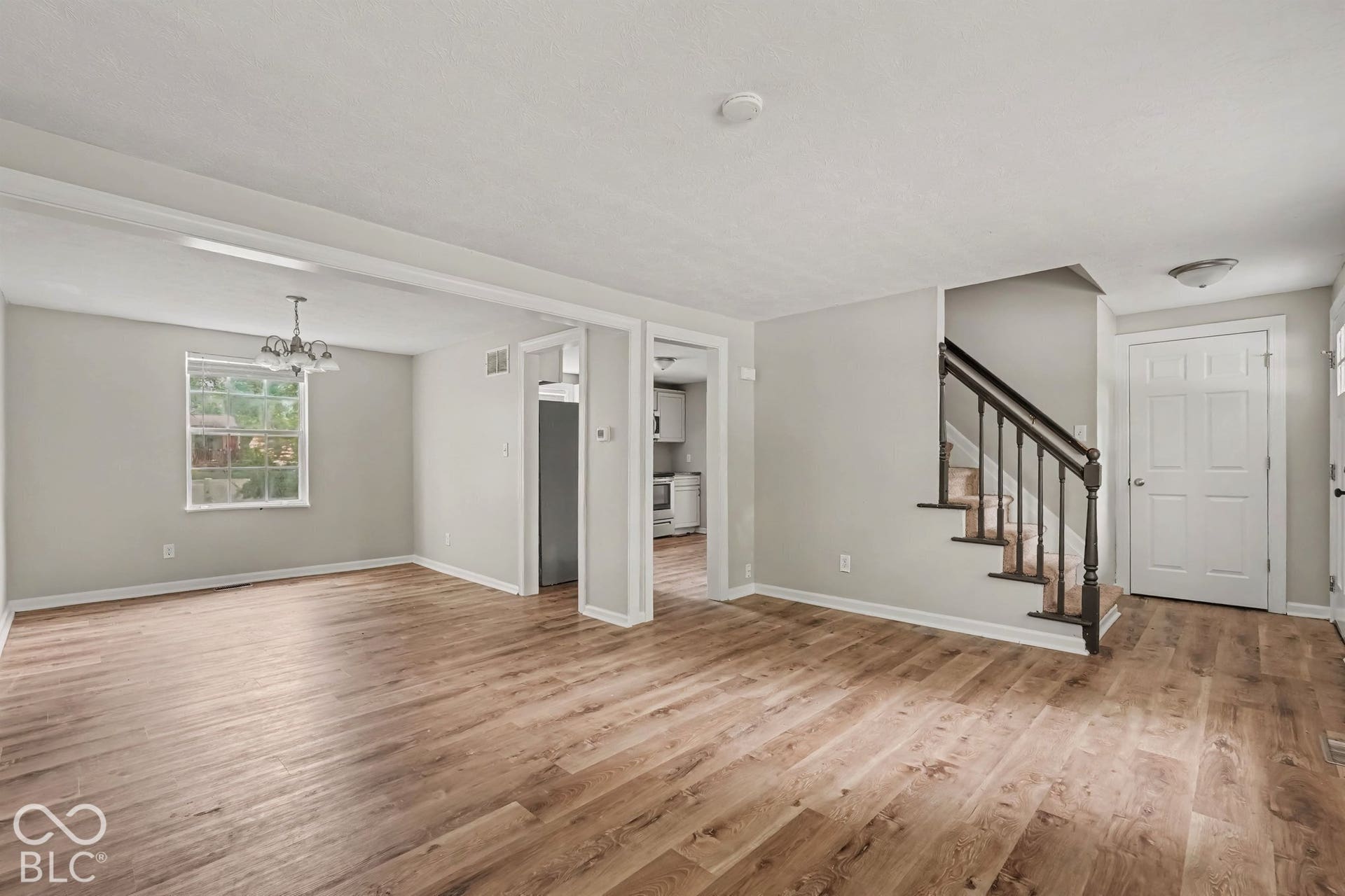Wood-finish flooring throughout, light gray wall paint, white trim, and a white ceiling