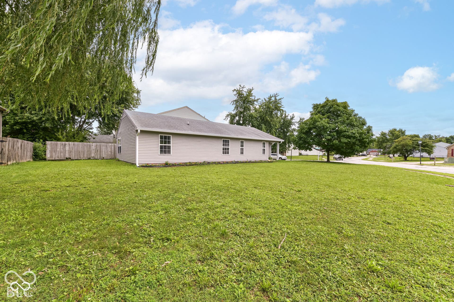 Expansive lawn with a partial wood privacy fence