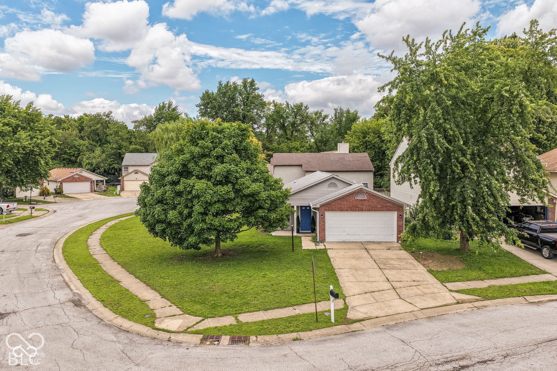 Two-story residence with a brick garage facade, an attached two-car garage, and a concrete driveway