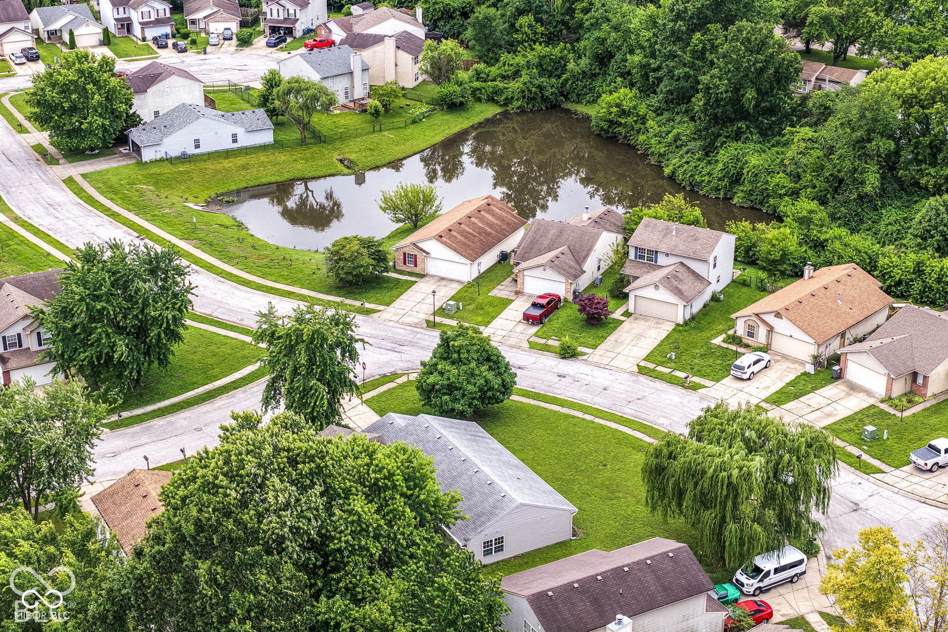 Neighborhood featuring a pond, mature trees, and detached residential structures