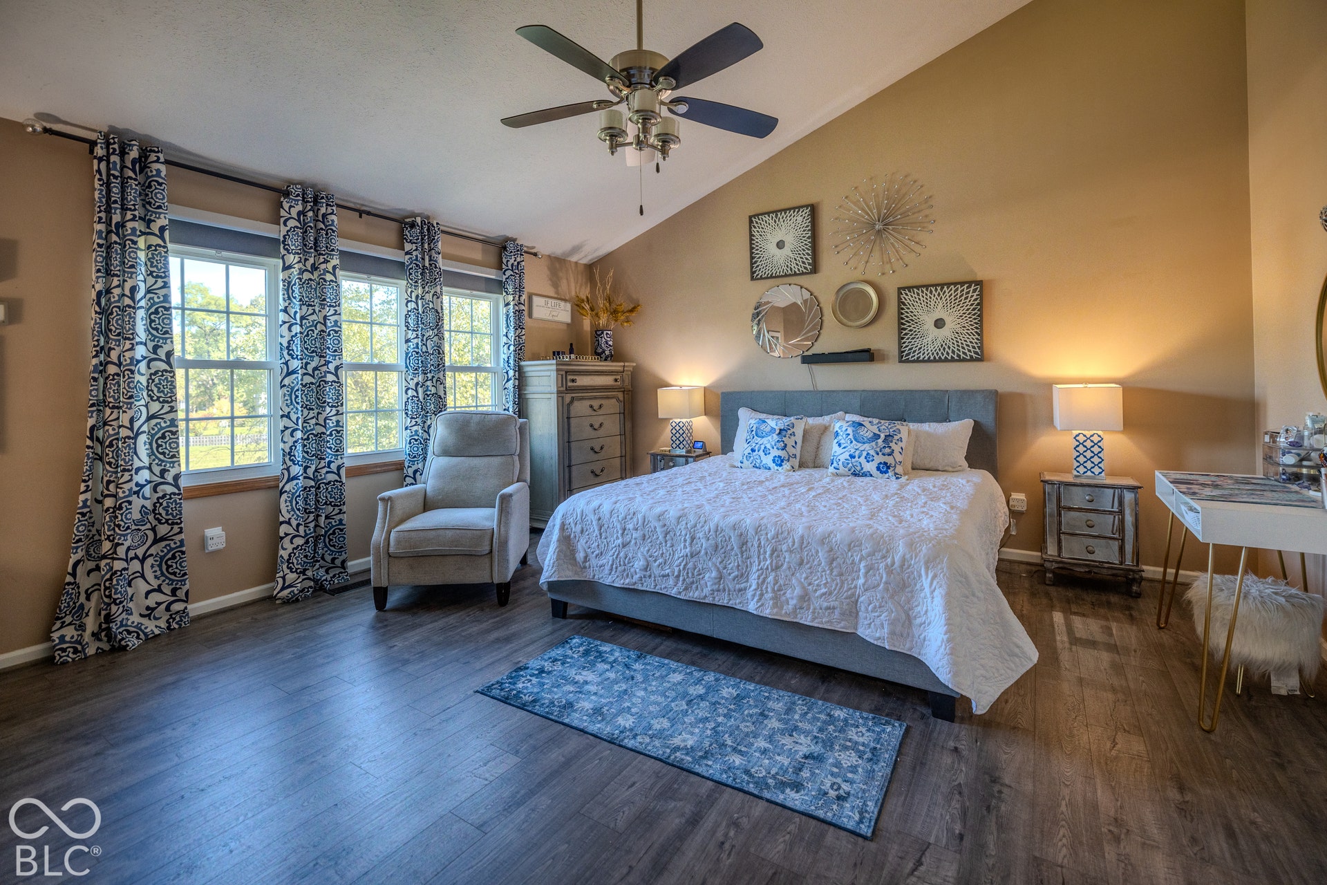6416 Manchester Drive, Fishers, IN 46038 The primary bedroom offers vaulted ceilings that create a sense of spaciousness & luxury. Large windows fill the room with natural light, creating a serene retreat for relaxing & restful nights. Cordless roller blinds provide privacy & light control.
