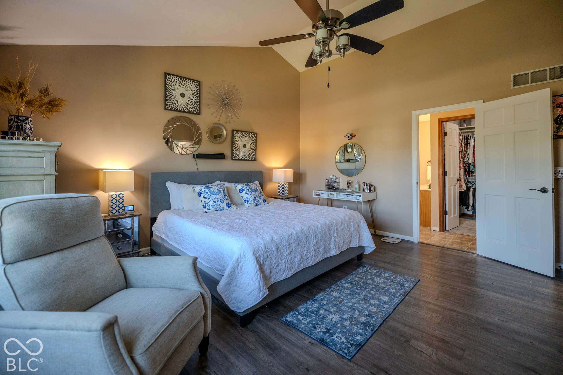 6416 Manchester Drive, Fishers, IN 46038 Vaulted ceiling, wood-finish flooring, ceiling fan with integrated lighting, paneled interior door, and an open doorway leading to the ensuite bath.