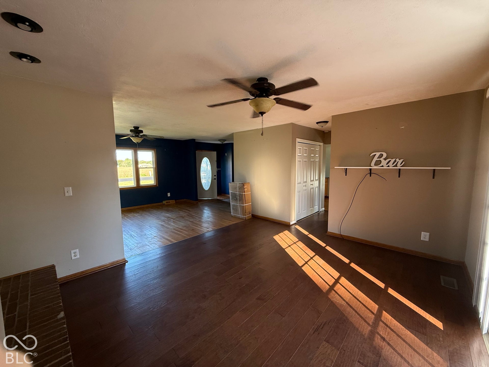 Spacious living area featuring wood-finish flooring, recessed lighting, and ceiling fans